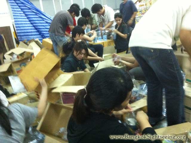 busy volunteers in Bangkok packing flood relief items to be shipped to heavily affected areas